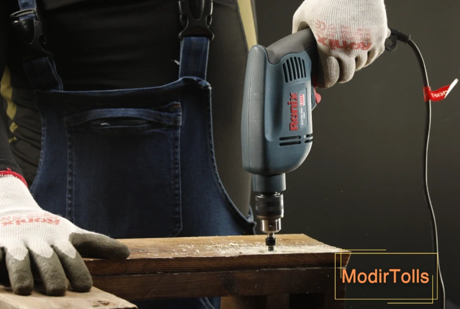 فردی در حال سوراخ کردن تخته چوب با دریل برقی