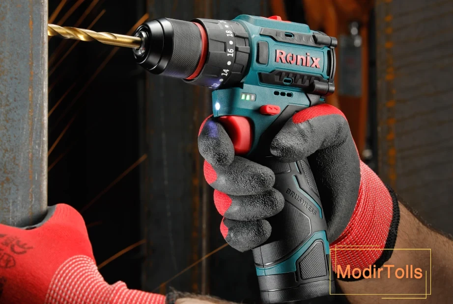 فردی با دستکش ایمنی در حال سوراخ کردن نبشی فولادی با دریل شارژی